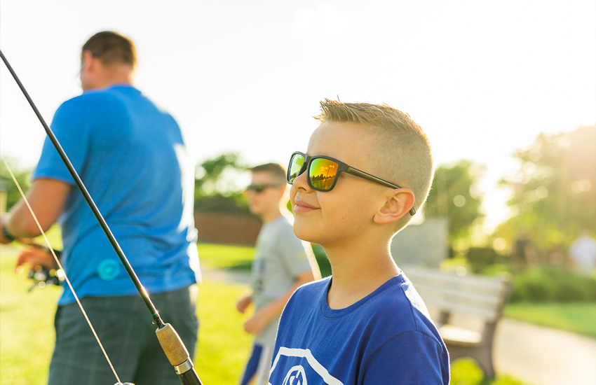 Boy fishing at Cast Park with father and brother