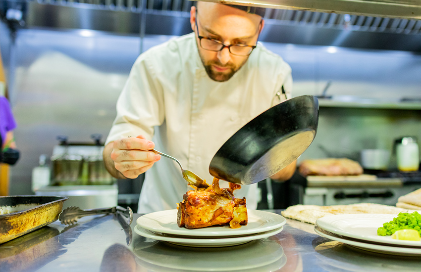 Chef cooking meal at Old Colonial Inn