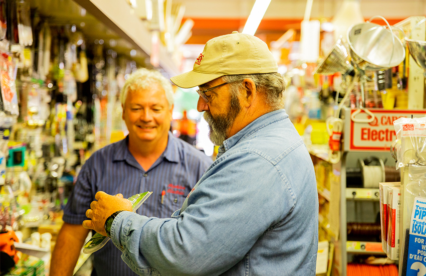 Shop owner helping customer find product